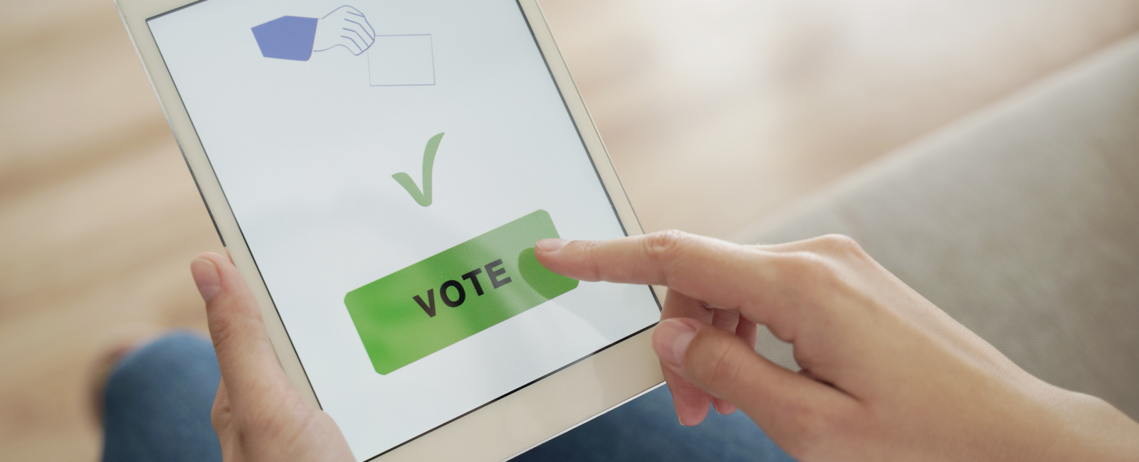 person casting their vote on a tablet